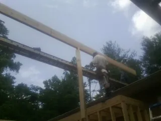 Carpenter setting a ridge beam over a new addition frame — Ice Dam Removal by Roofing Brothers in Woodstock