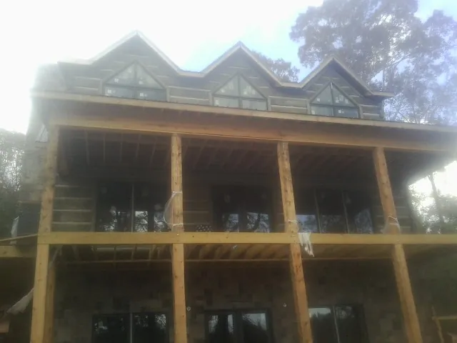 Dormers and porch framing on a large log home under construction in Woodstock